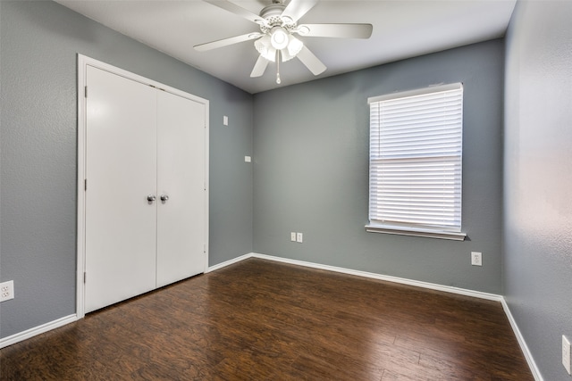 unfurnished bedroom featuring dark hardwood / wood-style floors, a closet, and ceiling fan