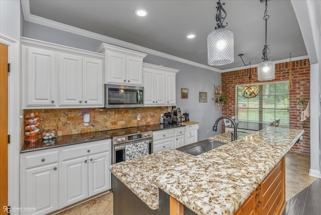 kitchen featuring appliances with stainless steel finishes, sink, an island with sink, and white cabinets