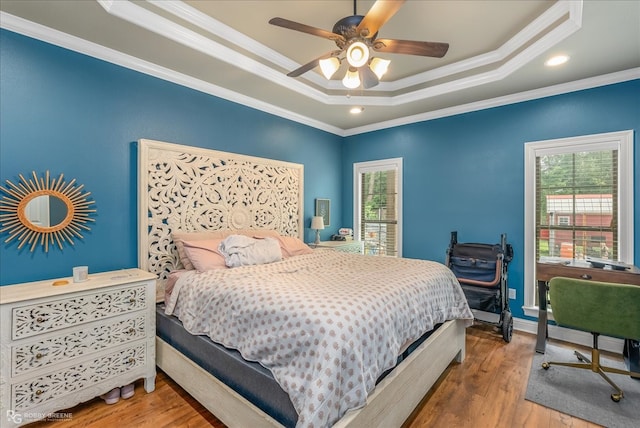 bedroom with multiple windows, wood-type flooring, crown molding, and ceiling fan