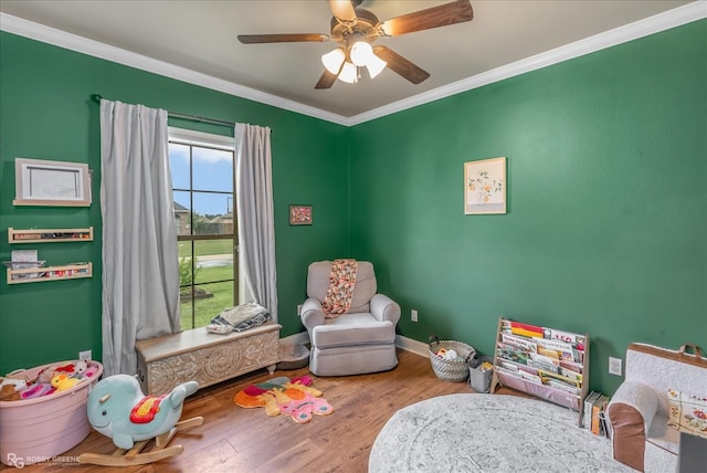 playroom featuring crown molding, hardwood / wood-style flooring, and ceiling fan