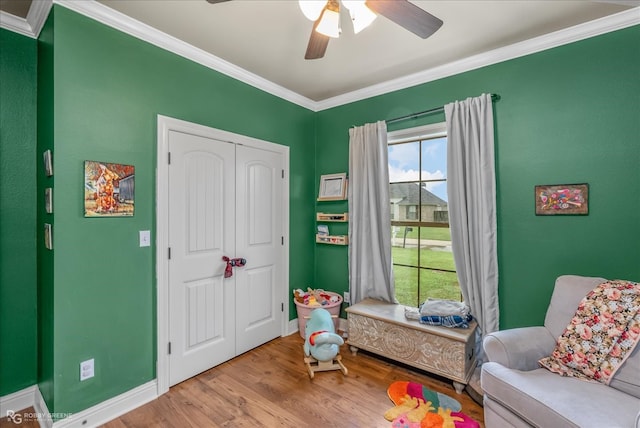 bedroom with crown molding, a closet, light wood-type flooring, and ceiling fan