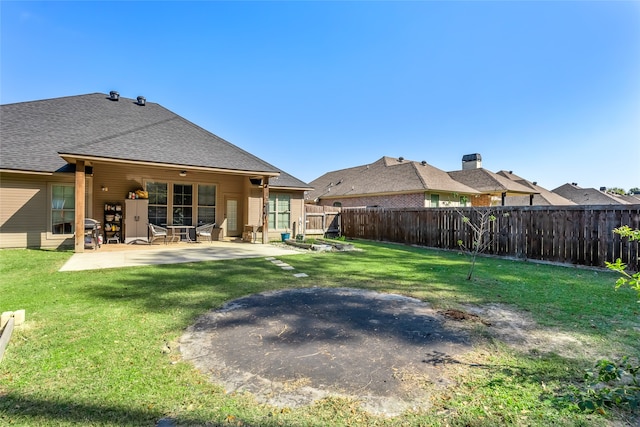 rear view of house with a yard and a patio