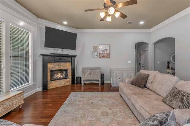 living room with crown molding, dark hardwood / wood-style flooring, and ceiling fan