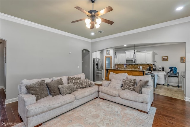 living room featuring ceiling fan, ornamental molding, and hardwood / wood-style floors