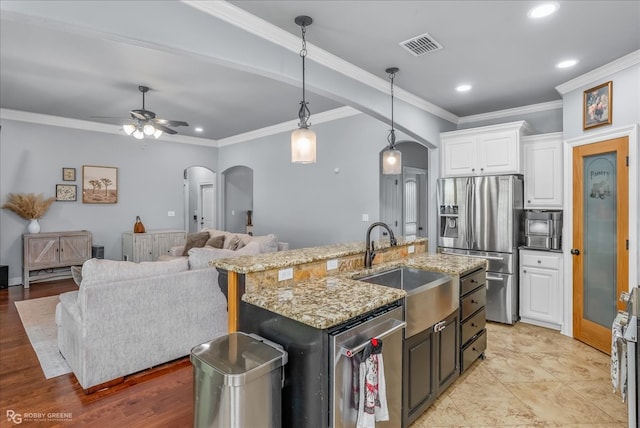 kitchen featuring ceiling fan, stainless steel appliances, decorative light fixtures, white cabinets, and ornamental molding