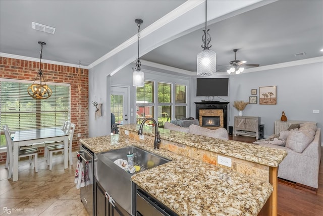 kitchen featuring ornamental molding, pendant lighting, and an island with sink