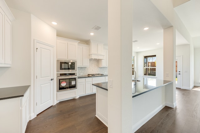 kitchen featuring appliances with stainless steel finishes, white cabinetry, and dark hardwood / wood-style floors