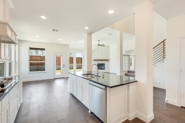 kitchen featuring dark wood-type flooring, stainless steel appliances, sink, white cabinetry, and ceiling fan