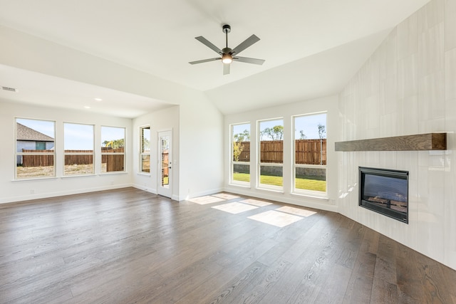 unfurnished living room featuring lofted ceiling, hardwood / wood-style floors, a tile fireplace, and plenty of natural light