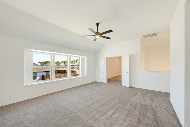 empty room with light carpet, vaulted ceiling, and ceiling fan