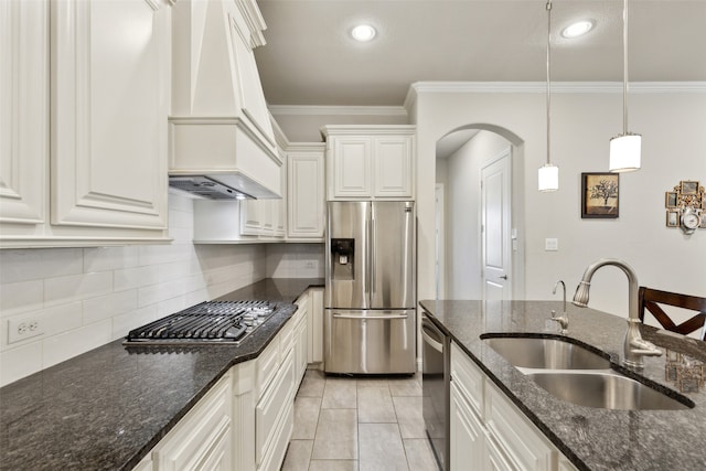 kitchen featuring stainless steel appliances, dark stone counters, sink, custom exhaust hood, and white cabinetry