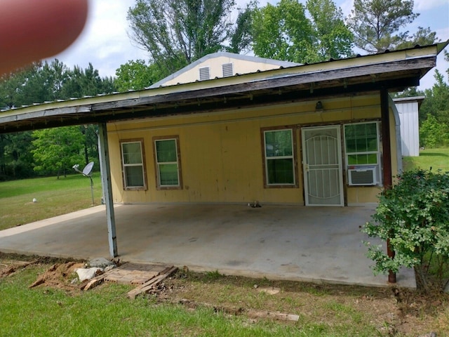 rear view of house with a yard, cooling unit, and a patio