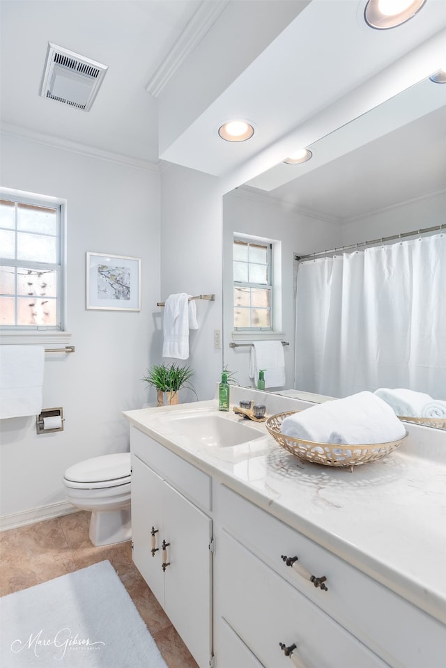 bathroom with toilet, ornamental molding, vanity, and plenty of natural light