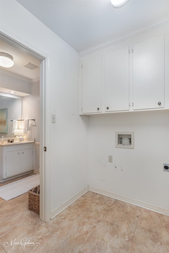 laundry area with hookup for an electric dryer, hookup for a washing machine, and cabinets