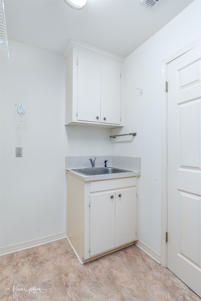 kitchen featuring white cabinetry and sink