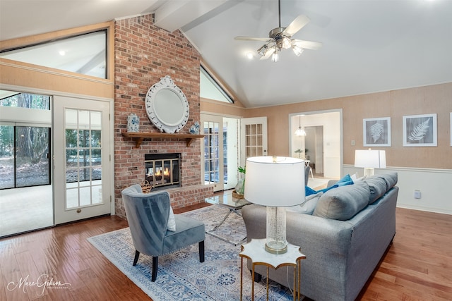 living room with hardwood / wood-style flooring, beam ceiling, a fireplace, high vaulted ceiling, and ceiling fan