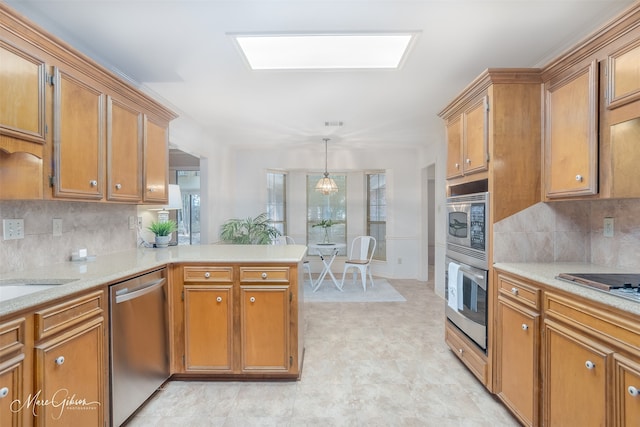 kitchen with hanging light fixtures, kitchen peninsula, stainless steel appliances, and tasteful backsplash