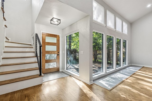 entryway featuring stairs, baseboards, and wood finished floors