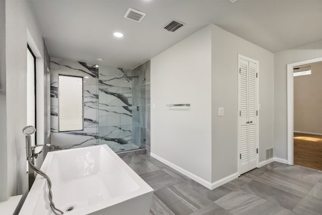 bathroom featuring a freestanding bath, a marble finish shower, visible vents, and a closet