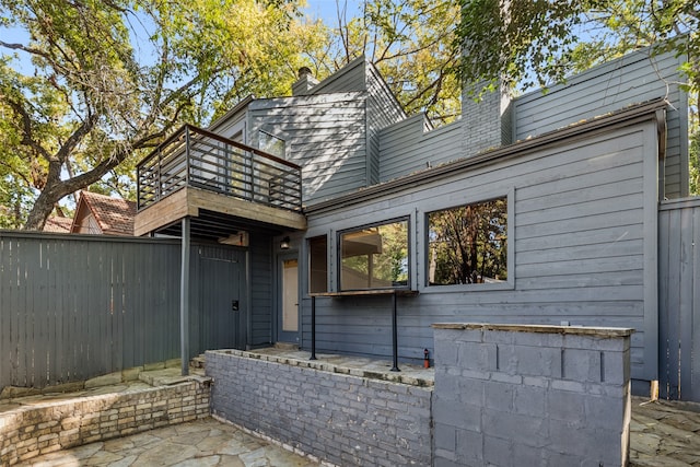 exterior space featuring a chimney and fence