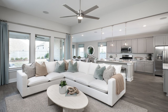 living room with ceiling fan, sink, plenty of natural light, and dark hardwood / wood-style flooring