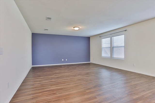 spare room with hardwood / wood-style floors and a textured ceiling