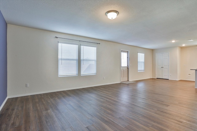 spare room featuring dark hardwood / wood-style floors and a textured ceiling