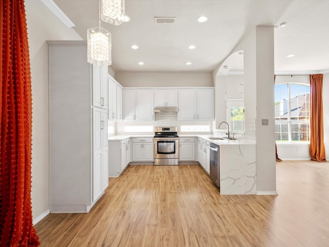 kitchen with white cabinetry, sink, stainless steel appliances, pendant lighting, and light hardwood / wood-style floors