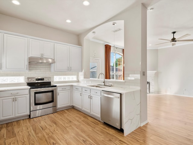 kitchen with white cabinets, appliances with stainless steel finishes, light hardwood / wood-style floors, and sink