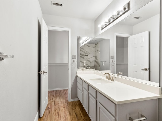 bathroom featuring a shower, vanity, and hardwood / wood-style flooring