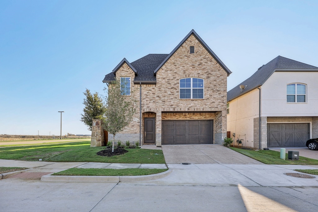 view of front of property featuring a front yard and a garage