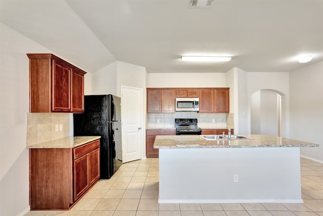 kitchen with sink, black appliances, light tile patterned floors, and tasteful backsplash