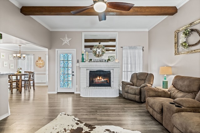 living room with dark wood-type flooring, crown molding, and a fireplace