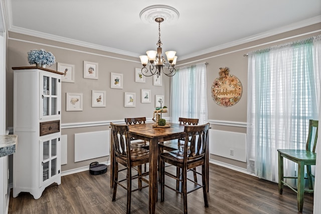 dining space featuring crown molding, an inviting chandelier, and dark hardwood / wood-style floors