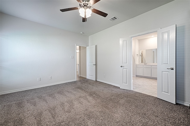 unfurnished bedroom featuring connected bathroom, light carpet, and ceiling fan