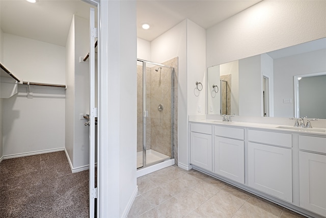 bathroom featuring a shower with door, vanity, and tile patterned flooring