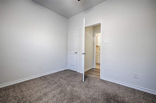 unfurnished bedroom with dark carpet