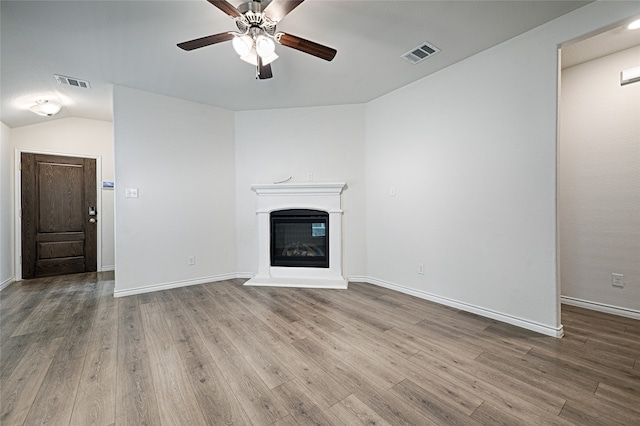 unfurnished living room with lofted ceiling, hardwood / wood-style flooring, and ceiling fan