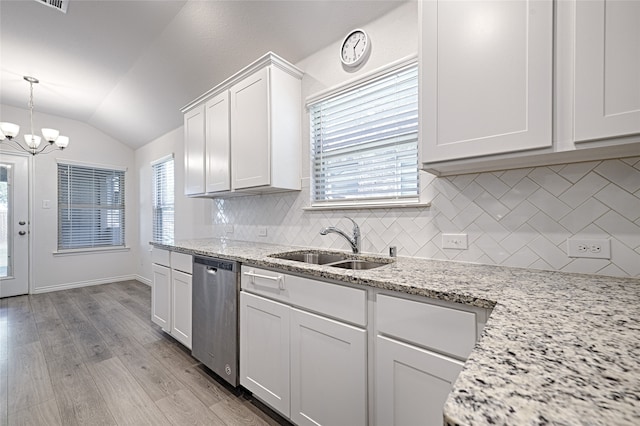 kitchen featuring lofted ceiling, backsplash, white cabinetry, stainless steel dishwasher, and sink