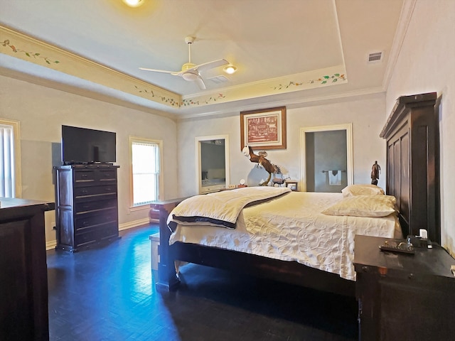 bedroom with dark hardwood / wood-style flooring, ornamental molding, a tray ceiling, and ceiling fan