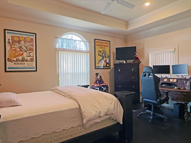 bedroom with crown molding, a tray ceiling, and ceiling fan