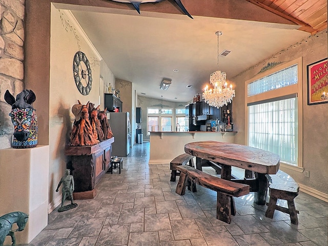 dining area featuring lofted ceiling, sink, and a notable chandelier