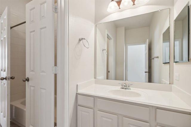 bathroom featuring tiled shower / bath and vanity