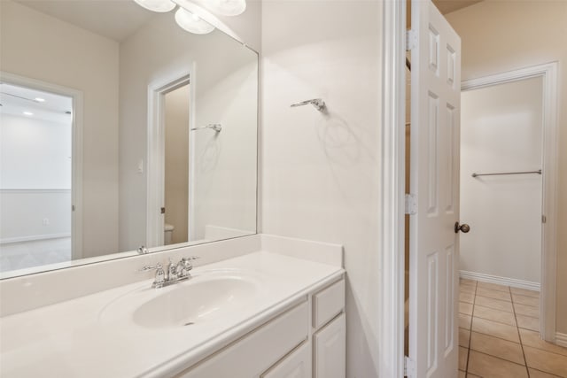 bathroom with toilet, vanity, and tile patterned flooring