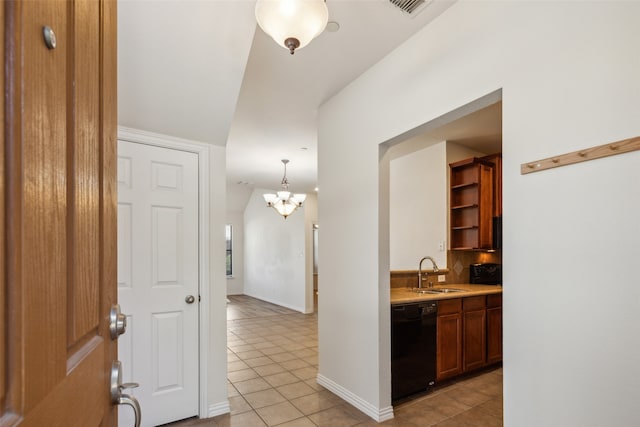 kitchen with sink, black dishwasher, light tile patterned flooring, and hanging light fixtures