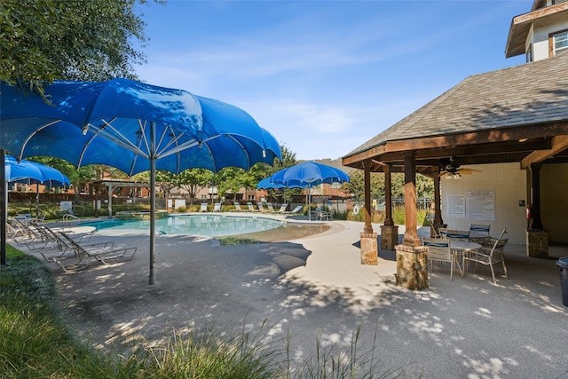 view of swimming pool with ceiling fan and a patio area