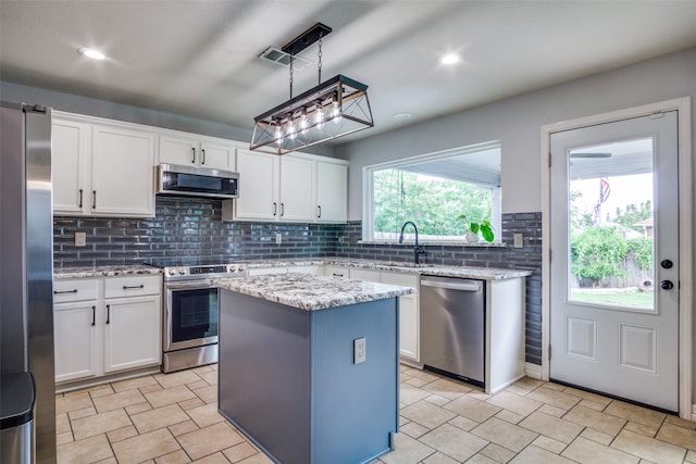 kitchen featuring appliances with stainless steel finishes, white cabinets, and a kitchen island