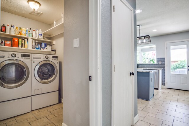 washroom with washer and clothes dryer and a textured ceiling