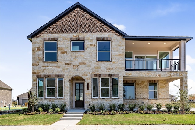 view of front of house featuring a balcony and a front lawn