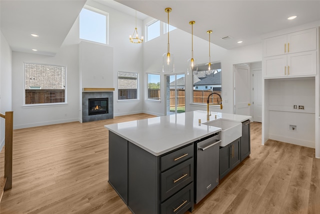 kitchen with sink, a wealth of natural light, light wood-type flooring, and hanging light fixtures